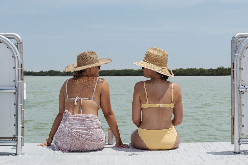 Two guests in straw hats on the bow